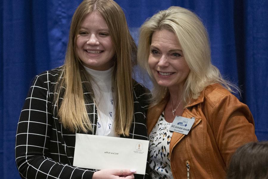 McClane Noffke stands with the president and CEO of the Wisconsin Broadcasters Association and holds her award.