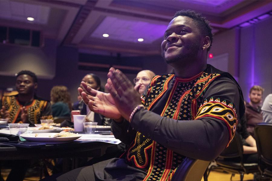 A student claps along to the music at the International Dinner.